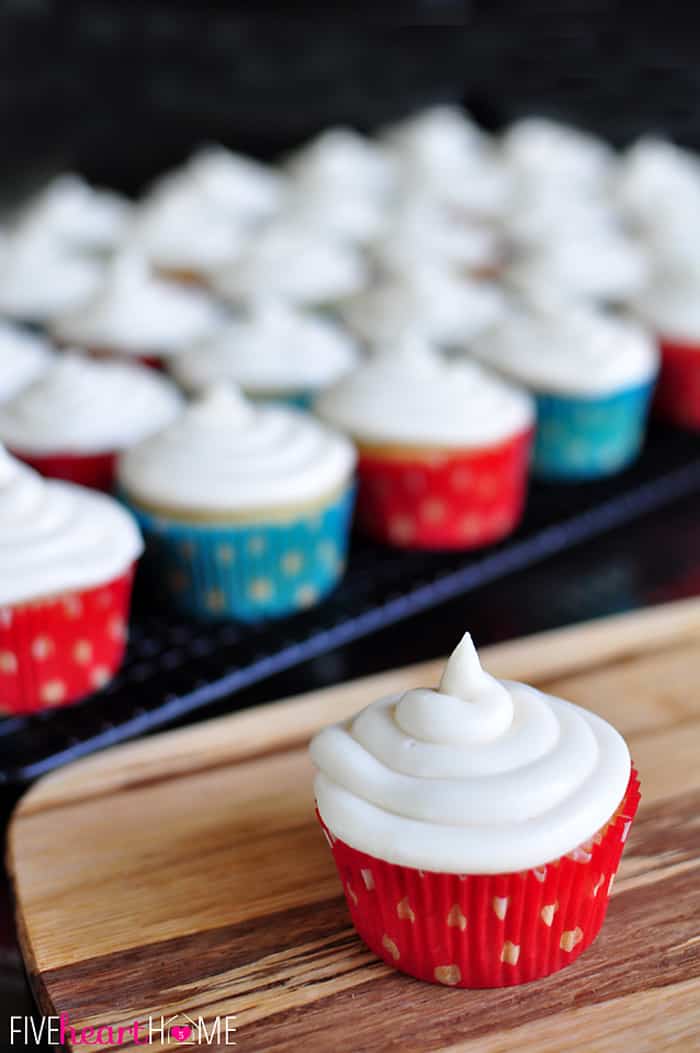 Vanilla Texas Sheet Cake Cupcake on table with more in background.