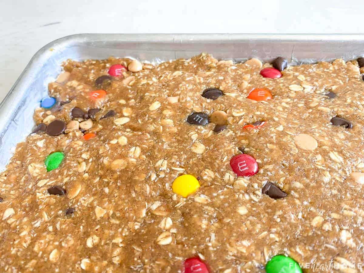 Monster Cookie Bars dough pressed into sheet pan.