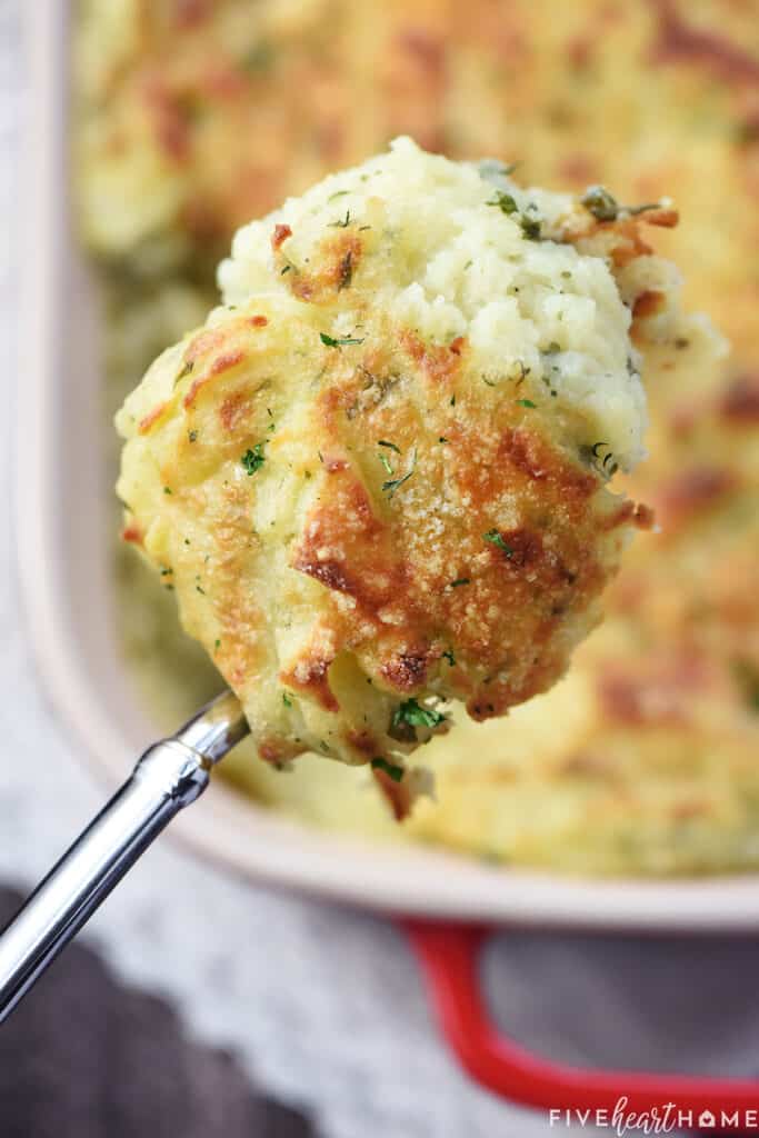 Make Ahead Mashed Potatoes, serving spoon held over dish.