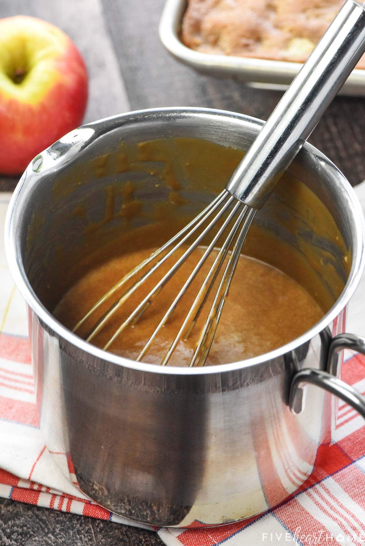 Caramel glaze in pot with whisk.
