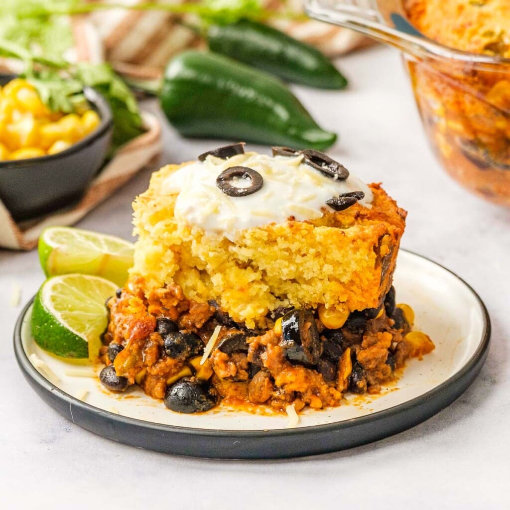 Mexican Cornbread Casserole on plate with limes.