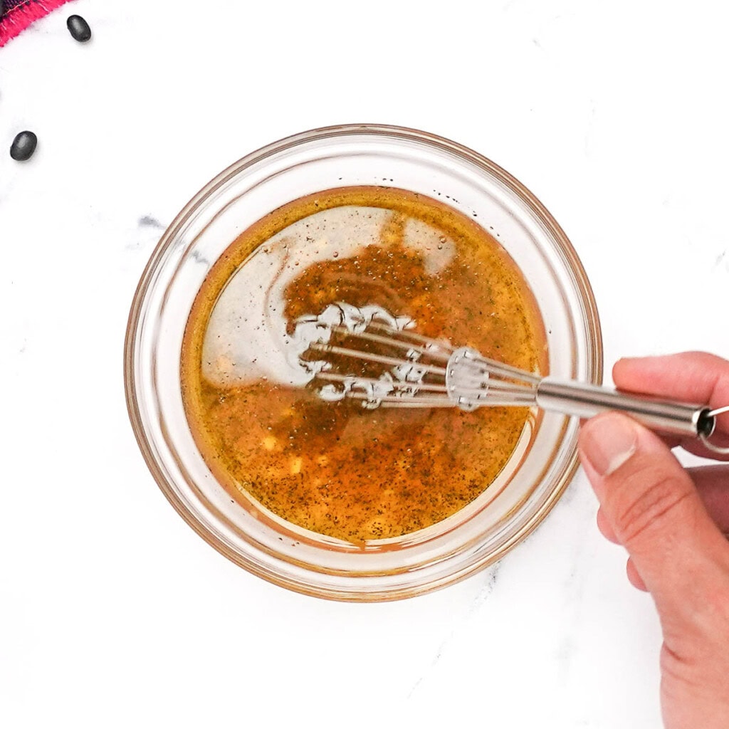 Whisking lime vinaigrette for black bean corn salad.