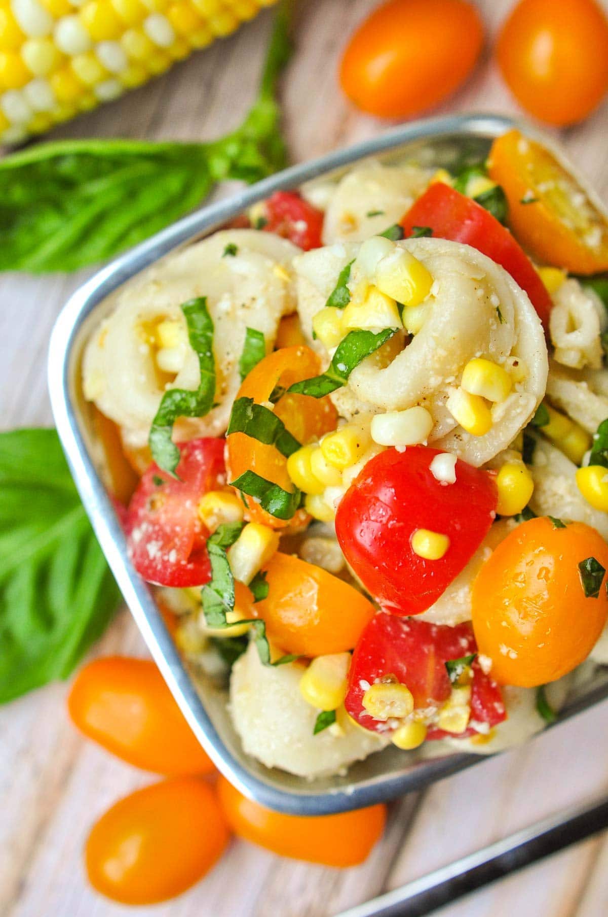 Close-up of Tortellini Pasta Salad with tomatoes, corn, and basil.