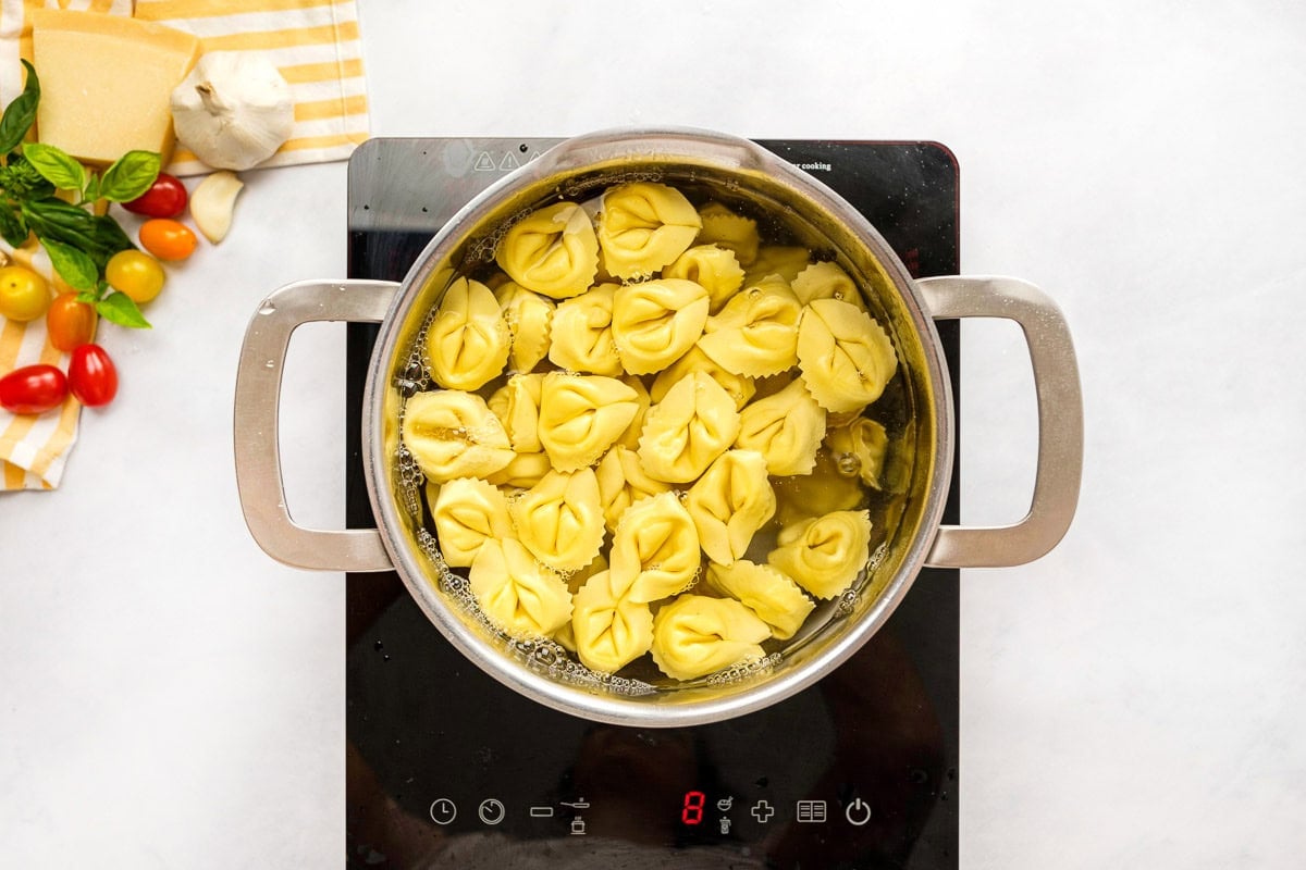 Boiling cheese tortellini in pot for tortellini pasta salad recipe.