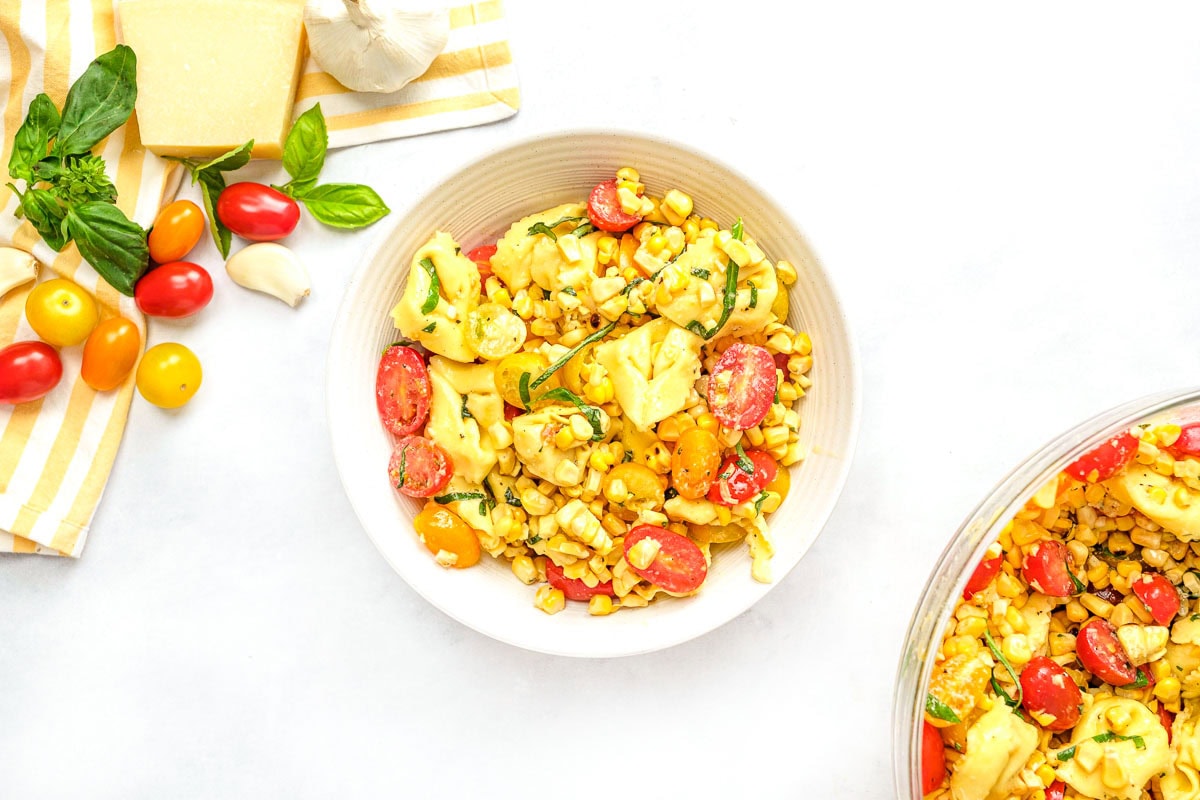 Tortellini pasta salad recipe in serving bowl and white bowl.