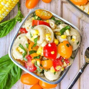 Tortellini Pasta Salad in pewter bowl with corn, basil, and tomatoes.