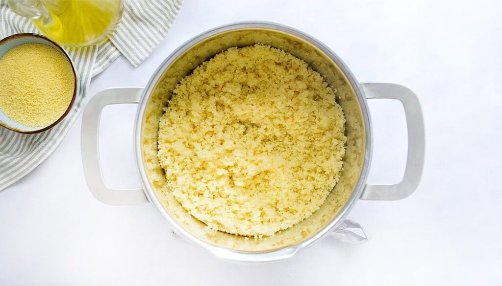 Cooked couscous in pot.