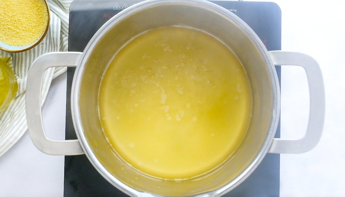 Chicken broth brought to a boil in pot.