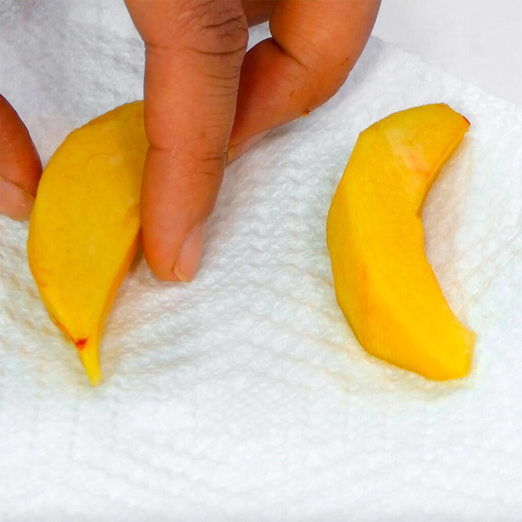 Drying peach slices on paper towel.