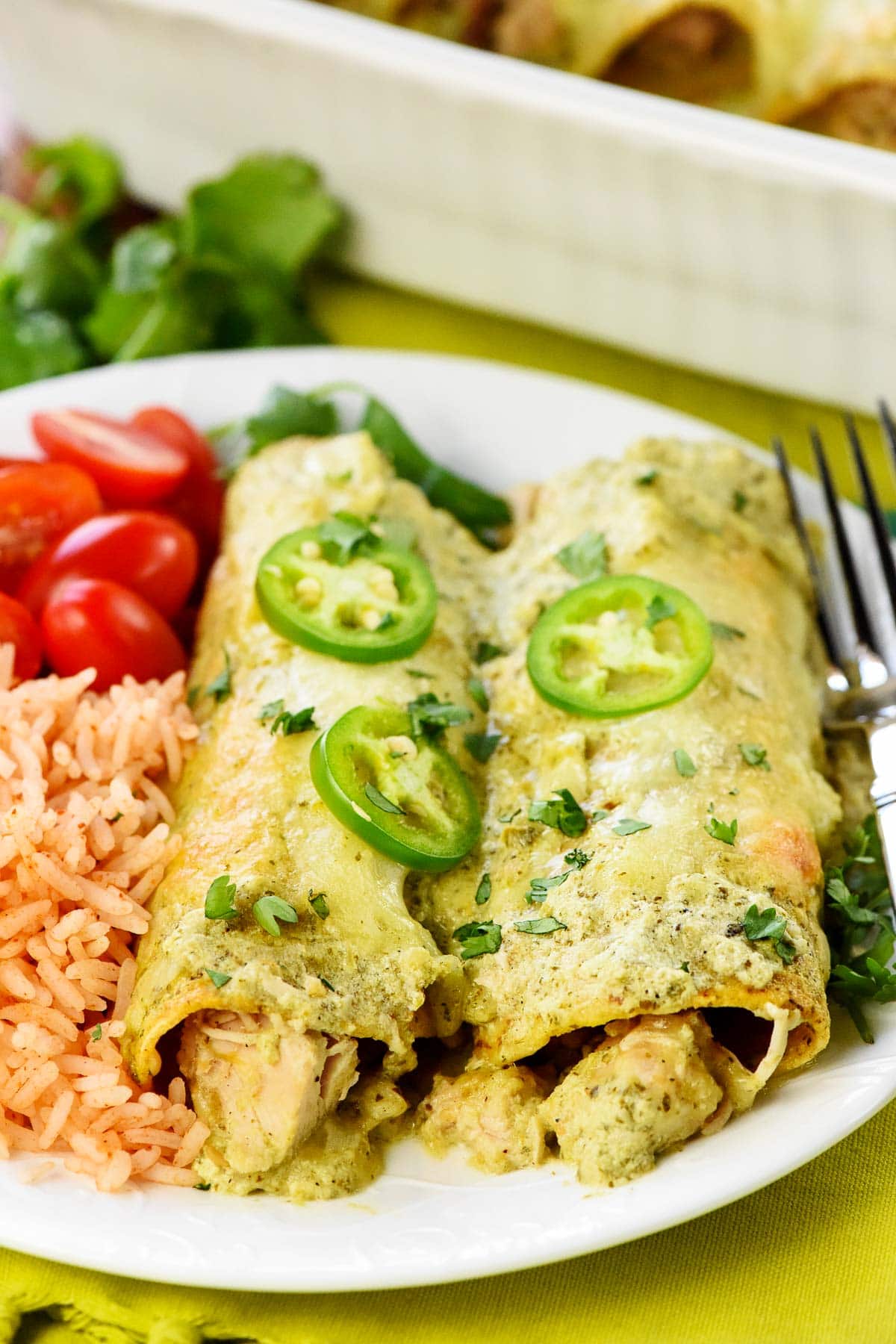 White Chicken Enchiladas with rice and tomatoes on side.