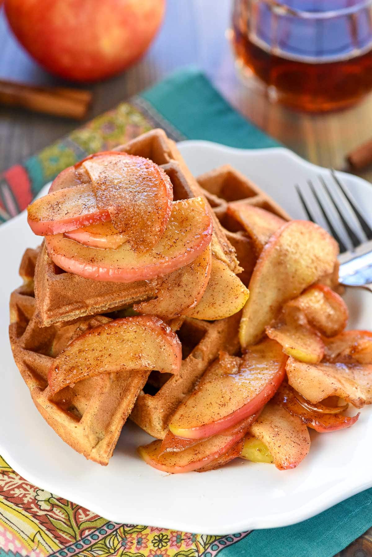 Apple Cinnamon Waffles with maple syrup in background.