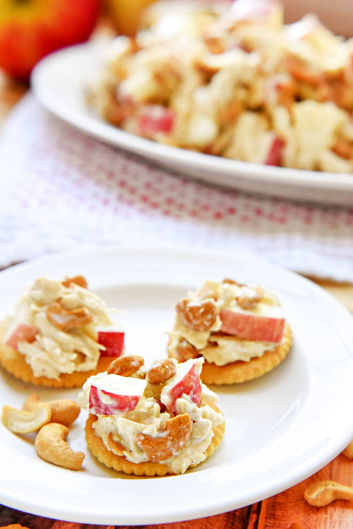 Chicken Salad with Apples on crackers with platter in background.