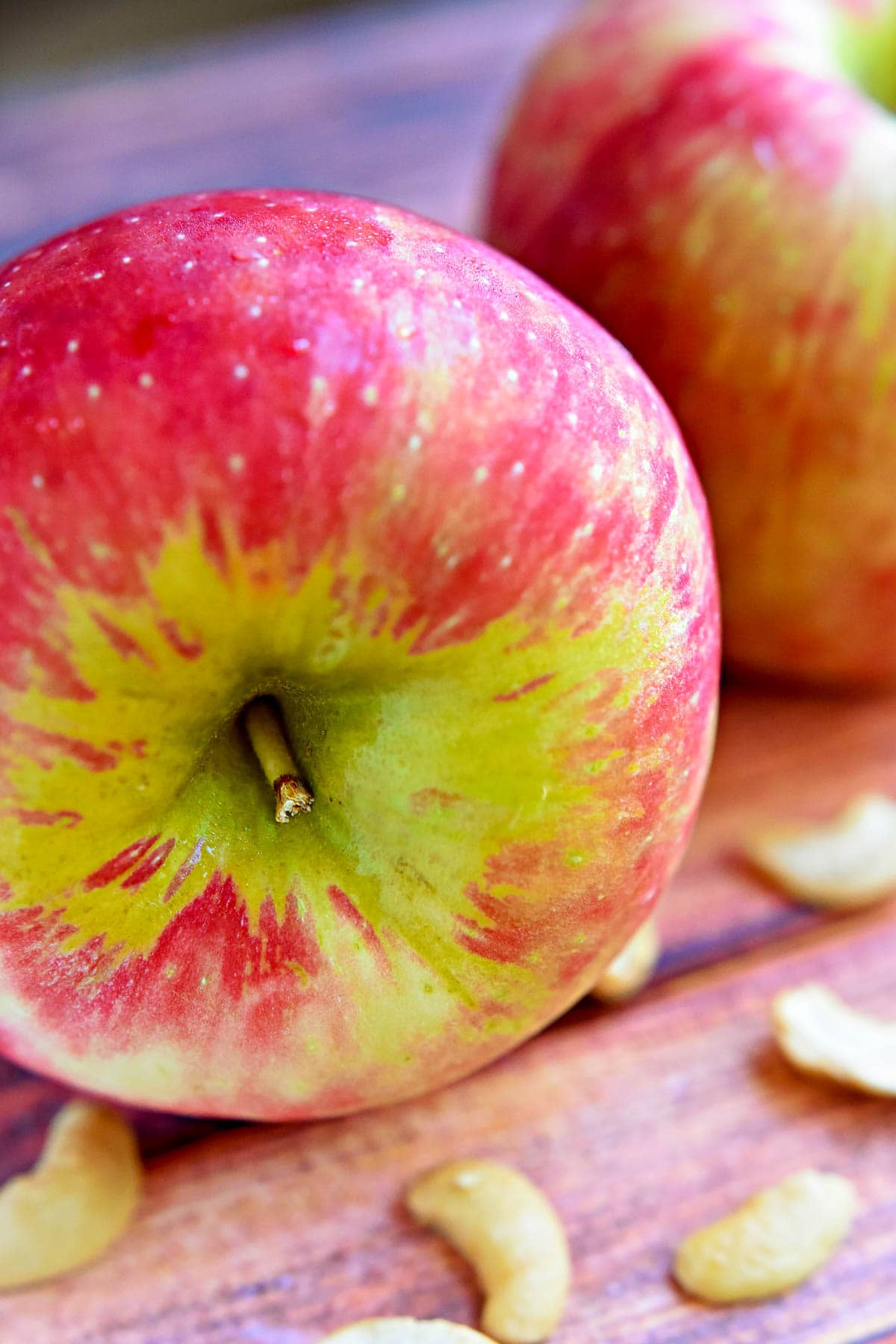 Close-up of Honeycrisps and cashews on table.