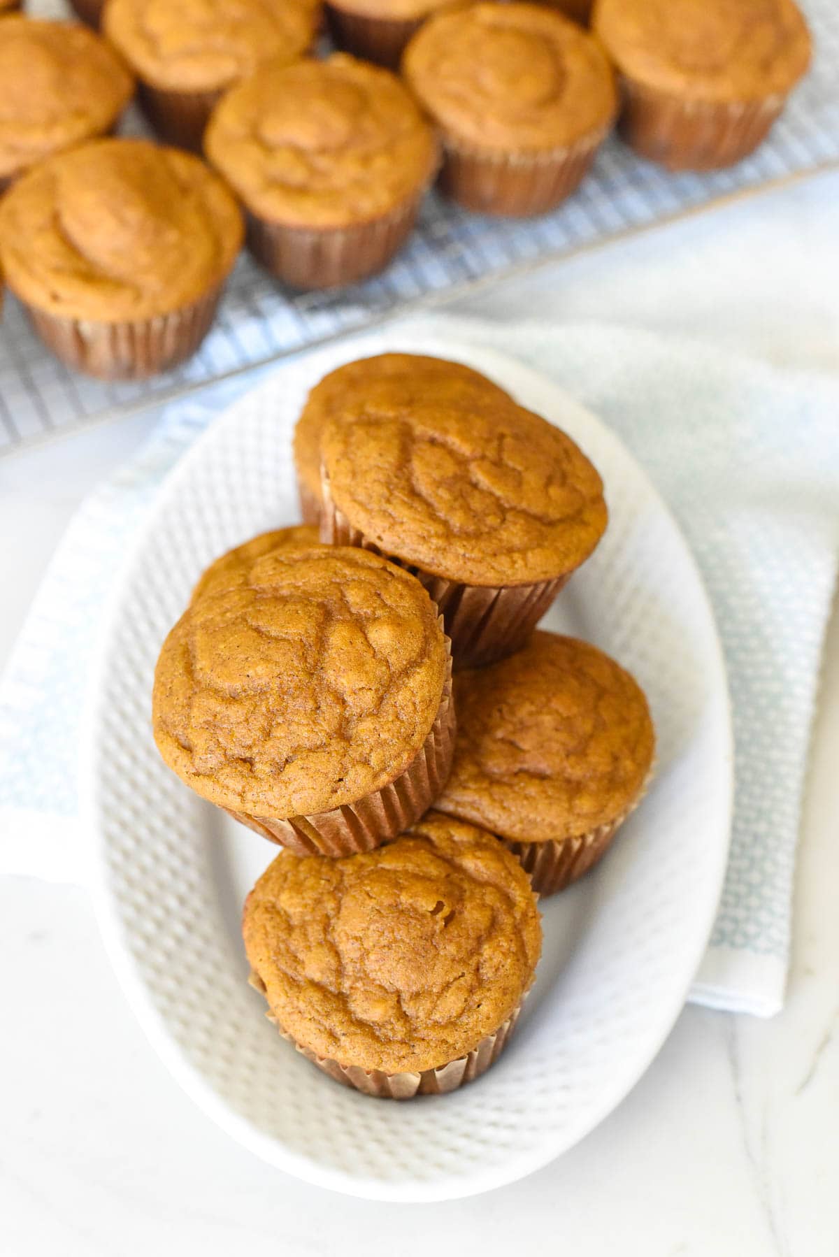 Healthy Pumpkin Muffins on platter with more muffin in background.