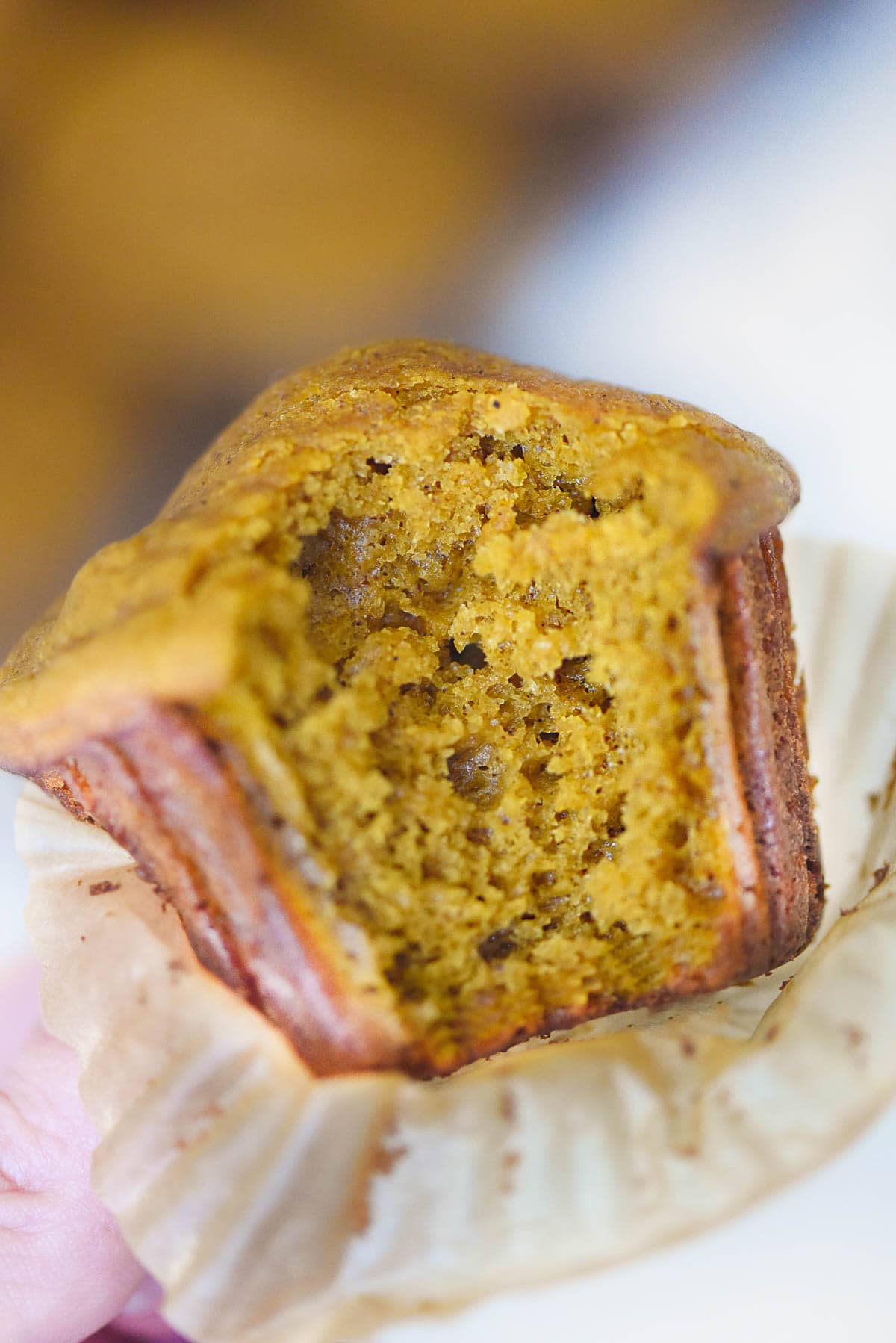 Close-up of pumpkin muffin recipe with missing bite.