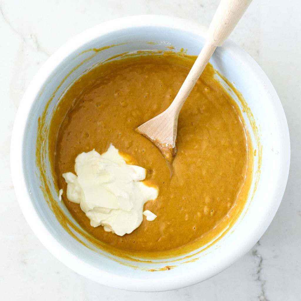 Adding yogurt to bowl.