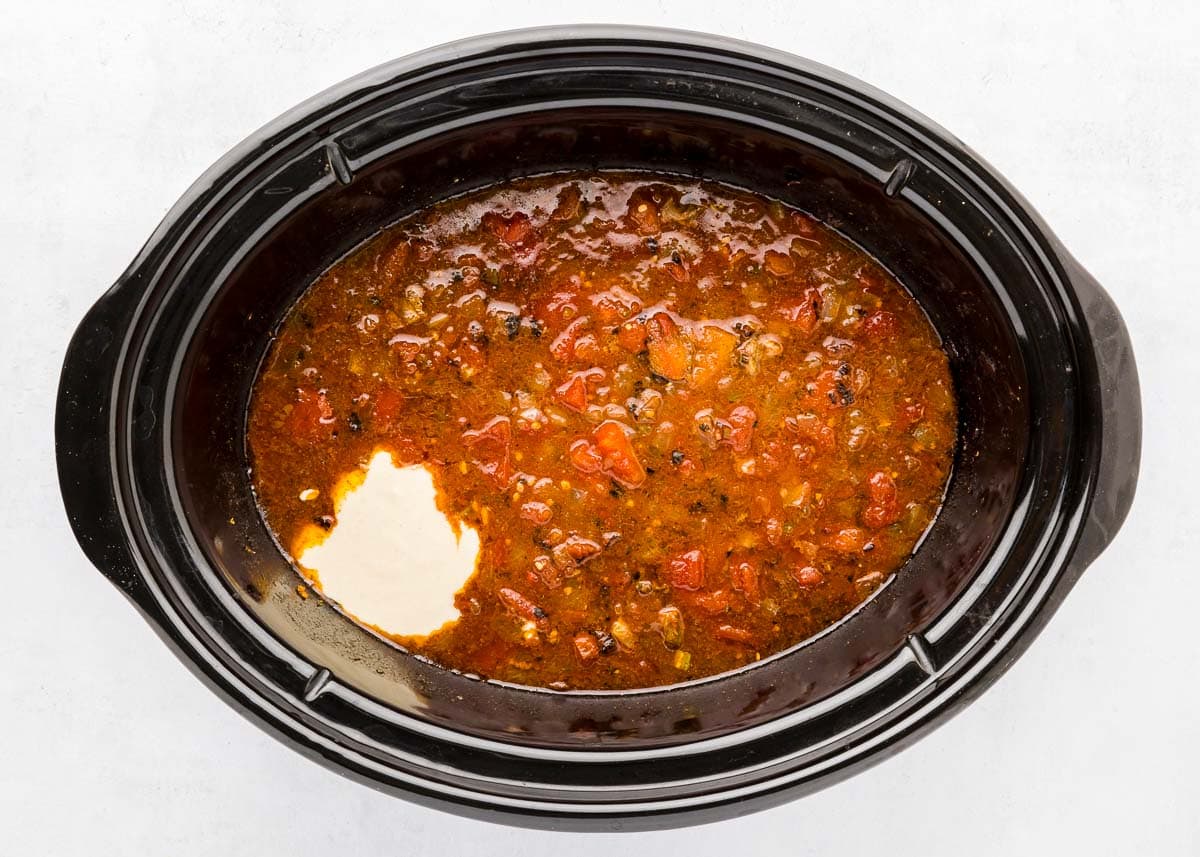 Adding masa mixture to Texas Chili recipe in crockpot.