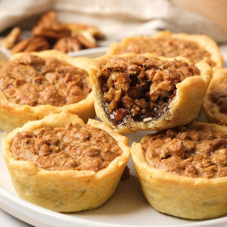 Mini Pecan Pies on plate with zoomed in missing bite.