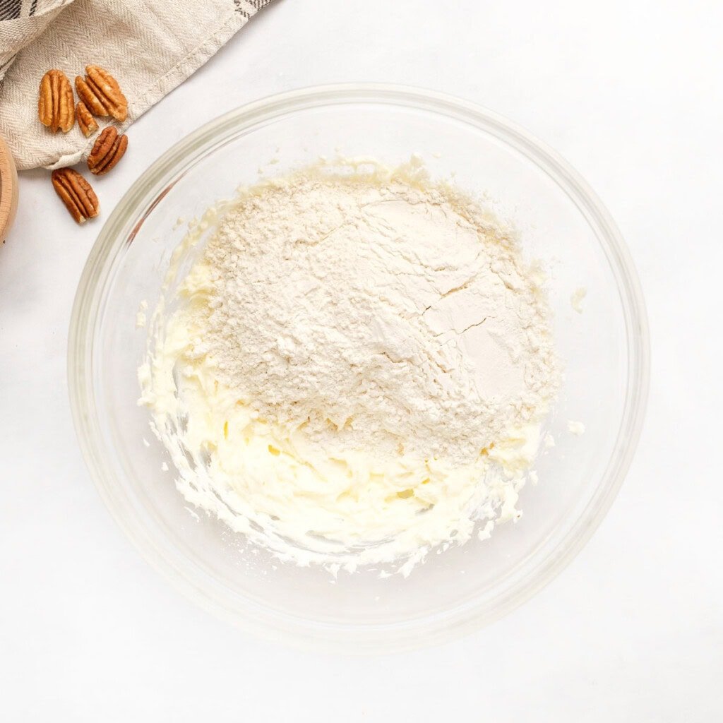 Adding flour to butter and cream cheese mixture.