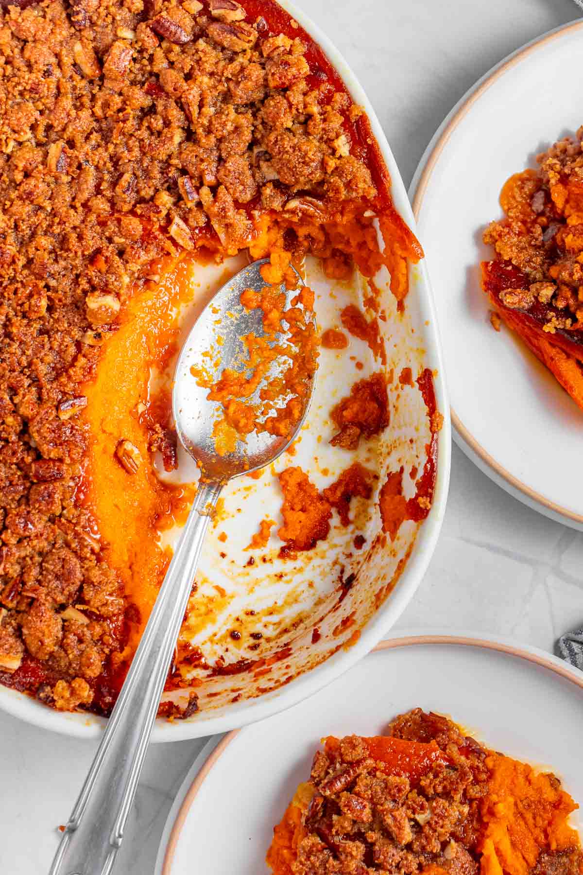 Old-Fashioned Sweet Potato Casserole with pecan topping in serving dish and on plates.