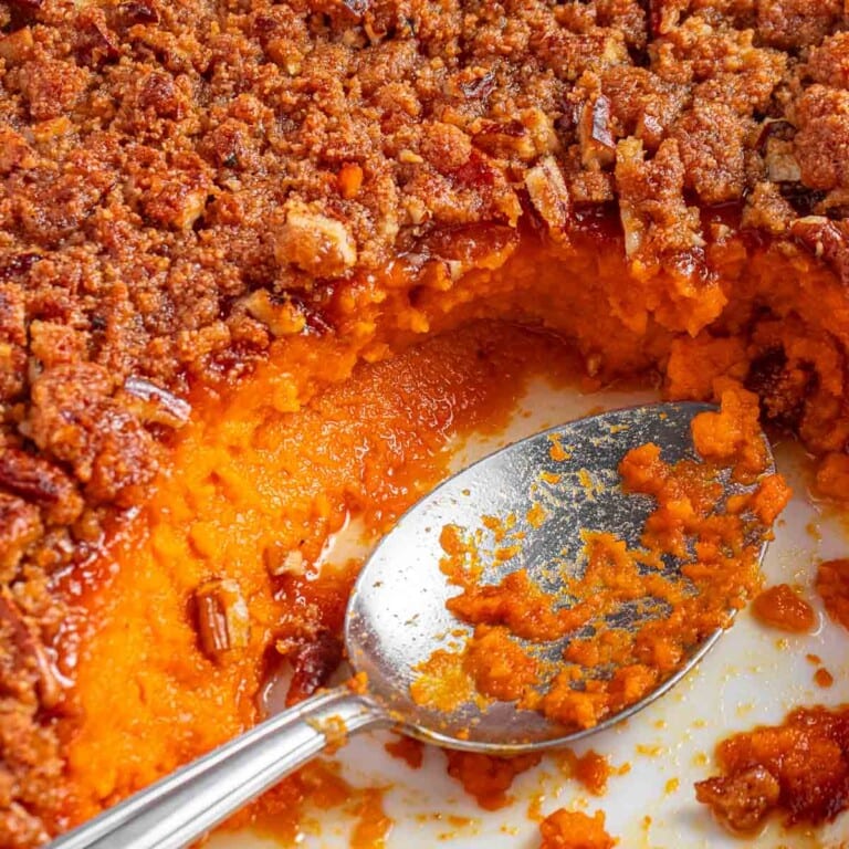 Old-Fashioned Sweet Potato Casserole in baking dish with missing scoop and spoon.