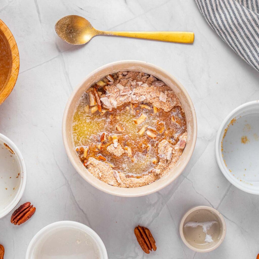 Mixing melted butter into pecan topping.