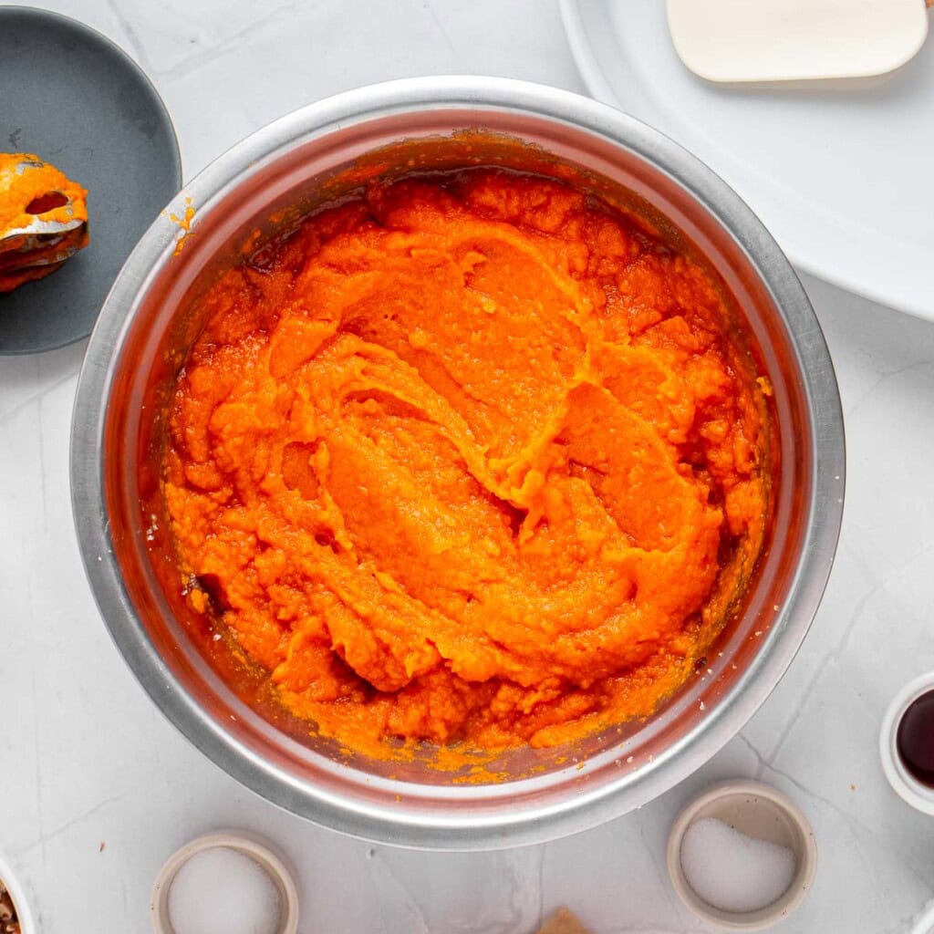 Mashed sweet potatoes mixed with sugars for Old-Fashioned Sweet Potato Casserole.