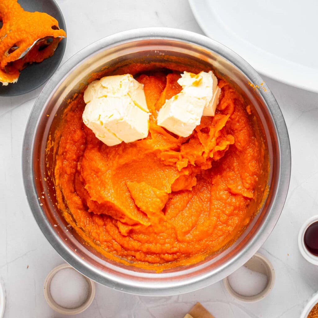 Adding butter to other ingredients in bowl.