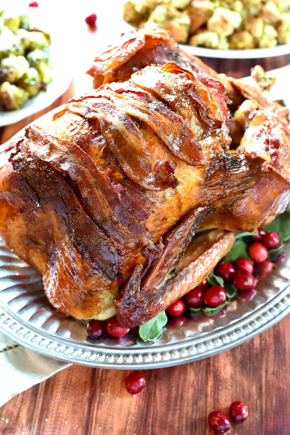 Bacon Wrapped Turkey with sage leaves and fresh cranberries.