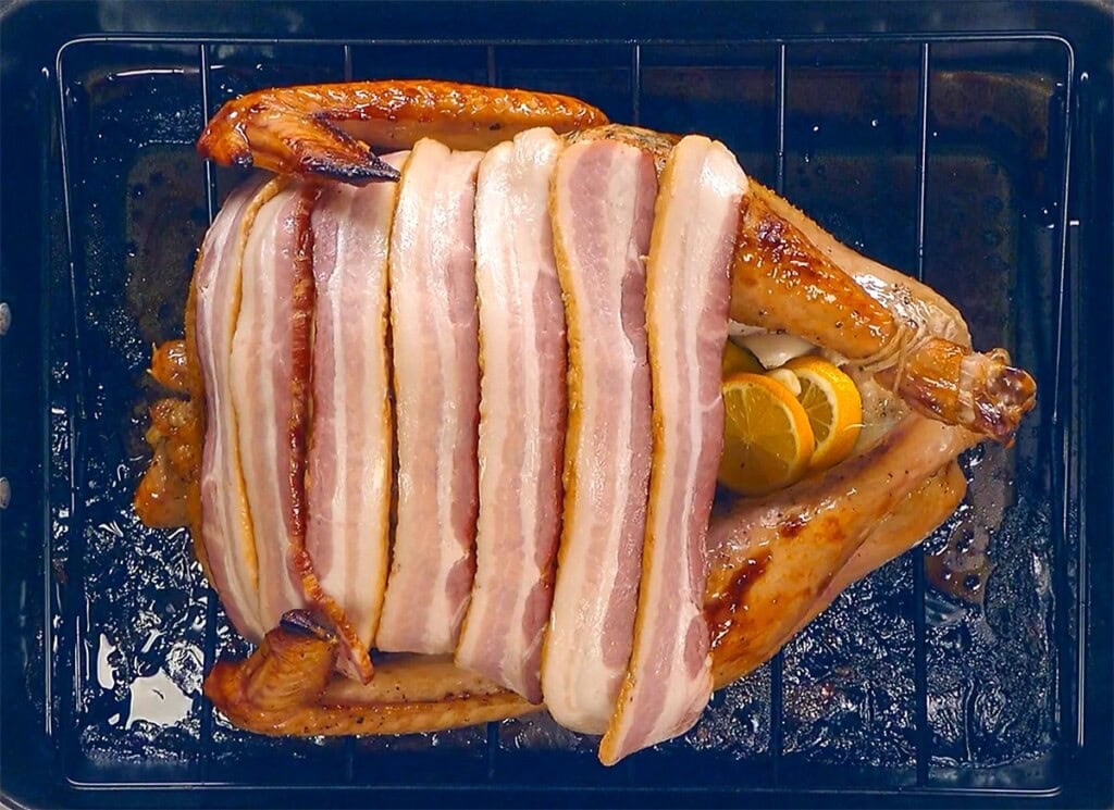 Bacon strips laid over Bacon Wrapped Turkey