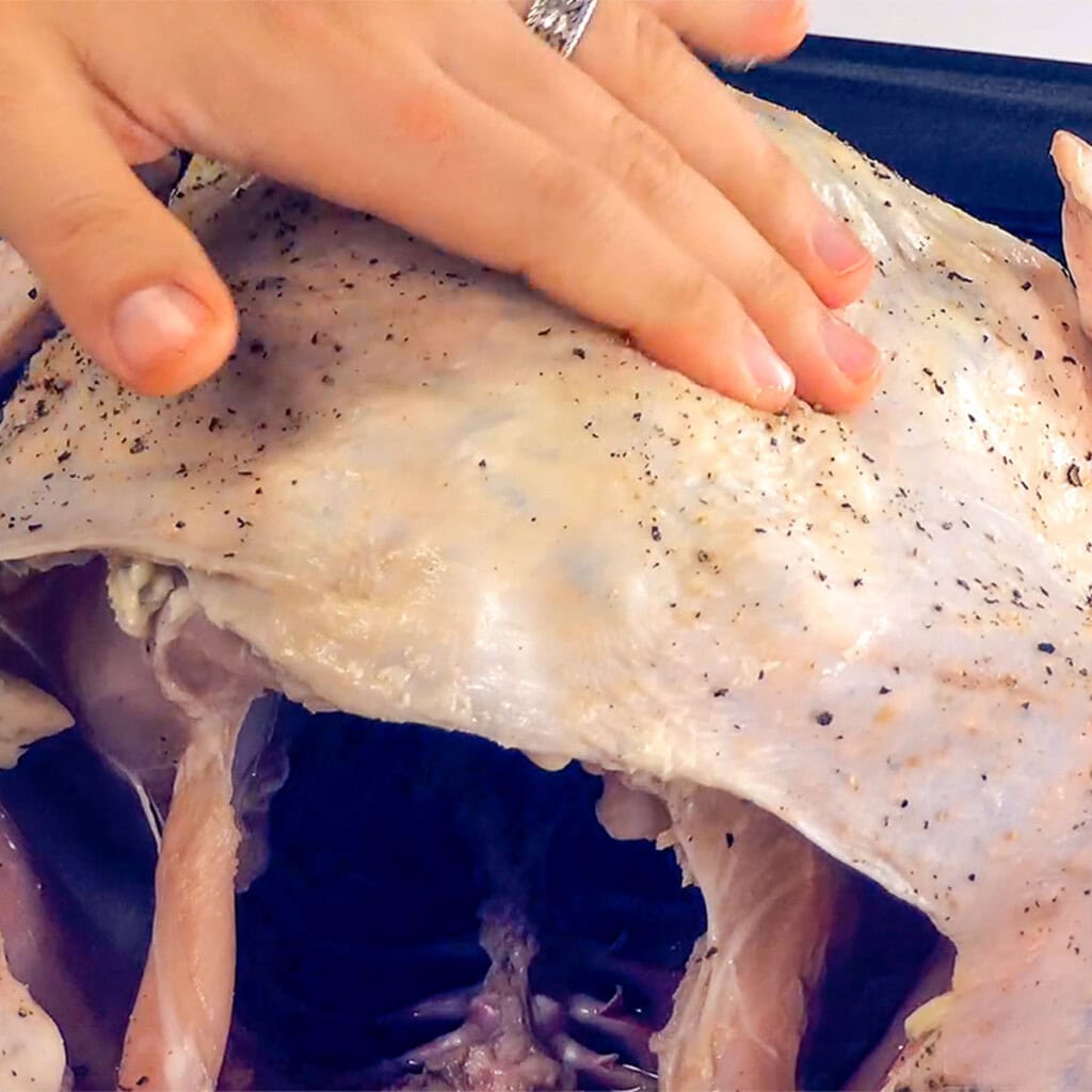 Smoothing butter under turkey skin.