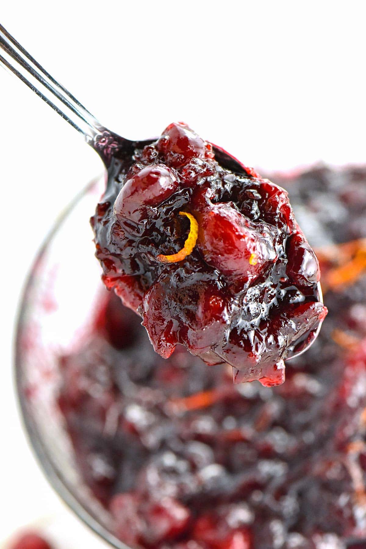 Recipe cranberry and orange sauce on spoon.