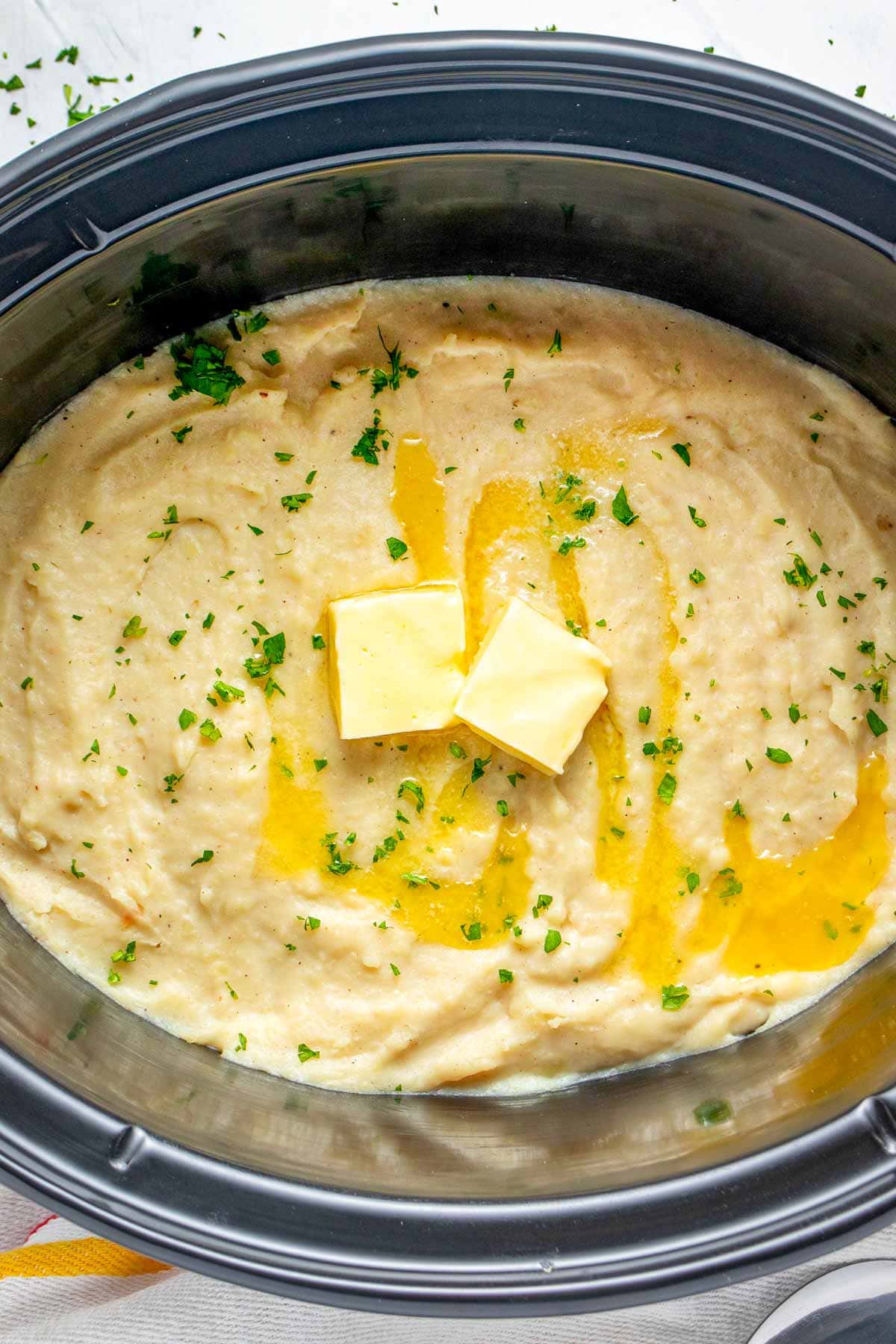 Aerial view of Crock Pot Mashed Potatoes with parsley and butter.