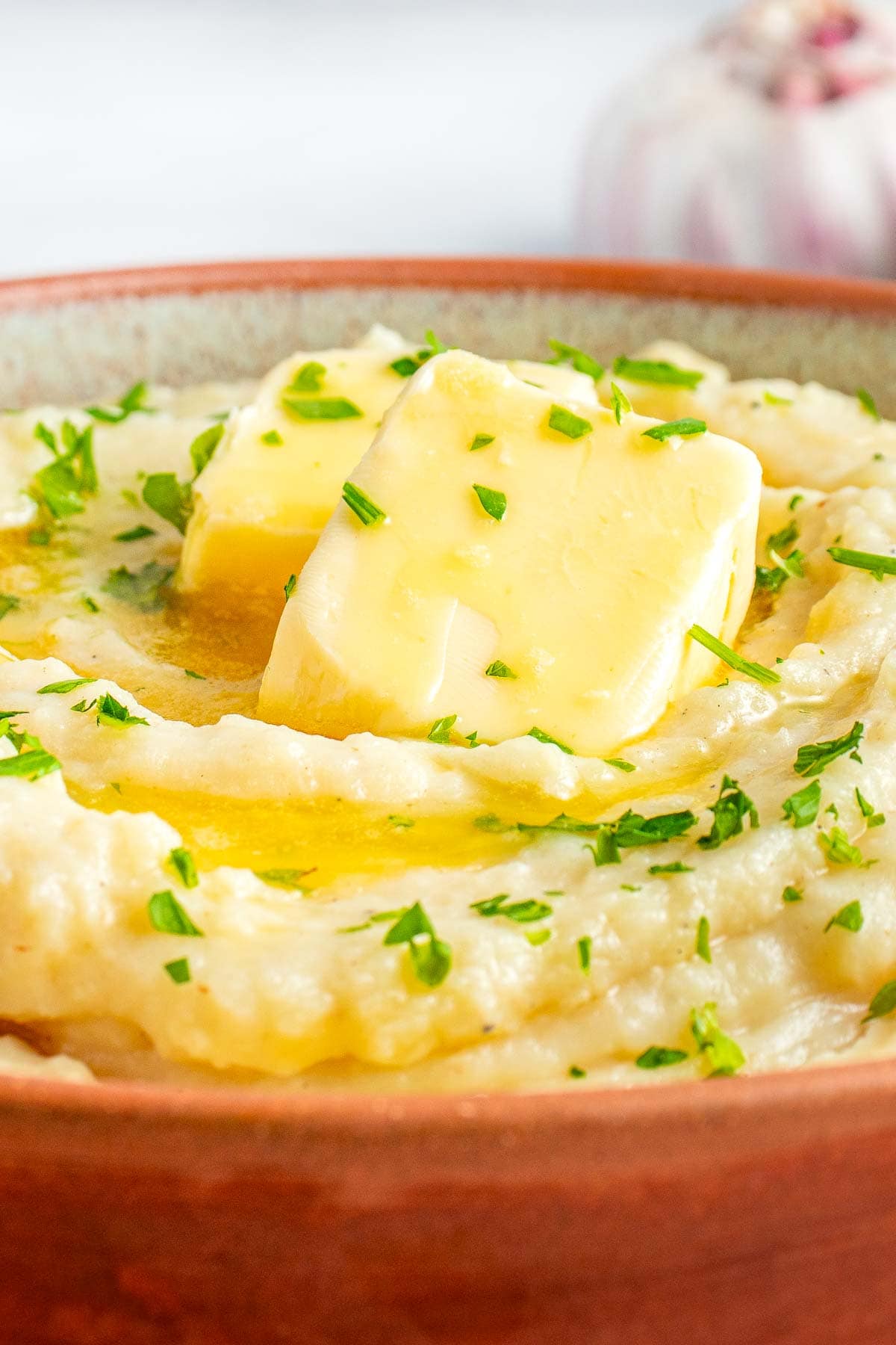 Close-up of butter melting over Crockpot Mashed Potatoes.