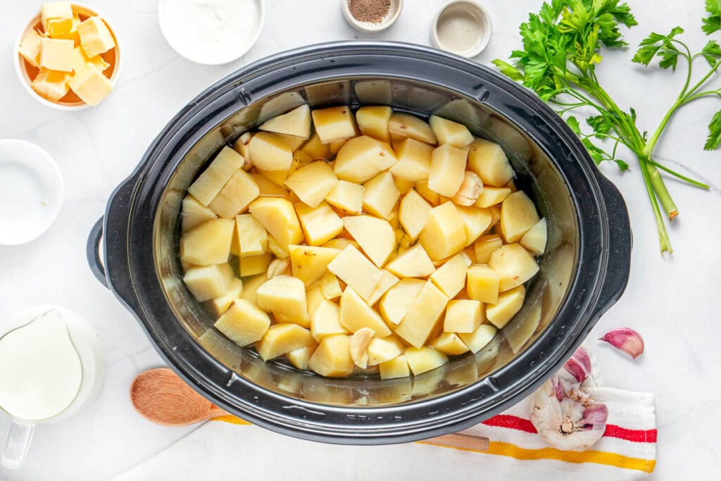 Cooked potato chunks for mashed potatoes in crock pot.