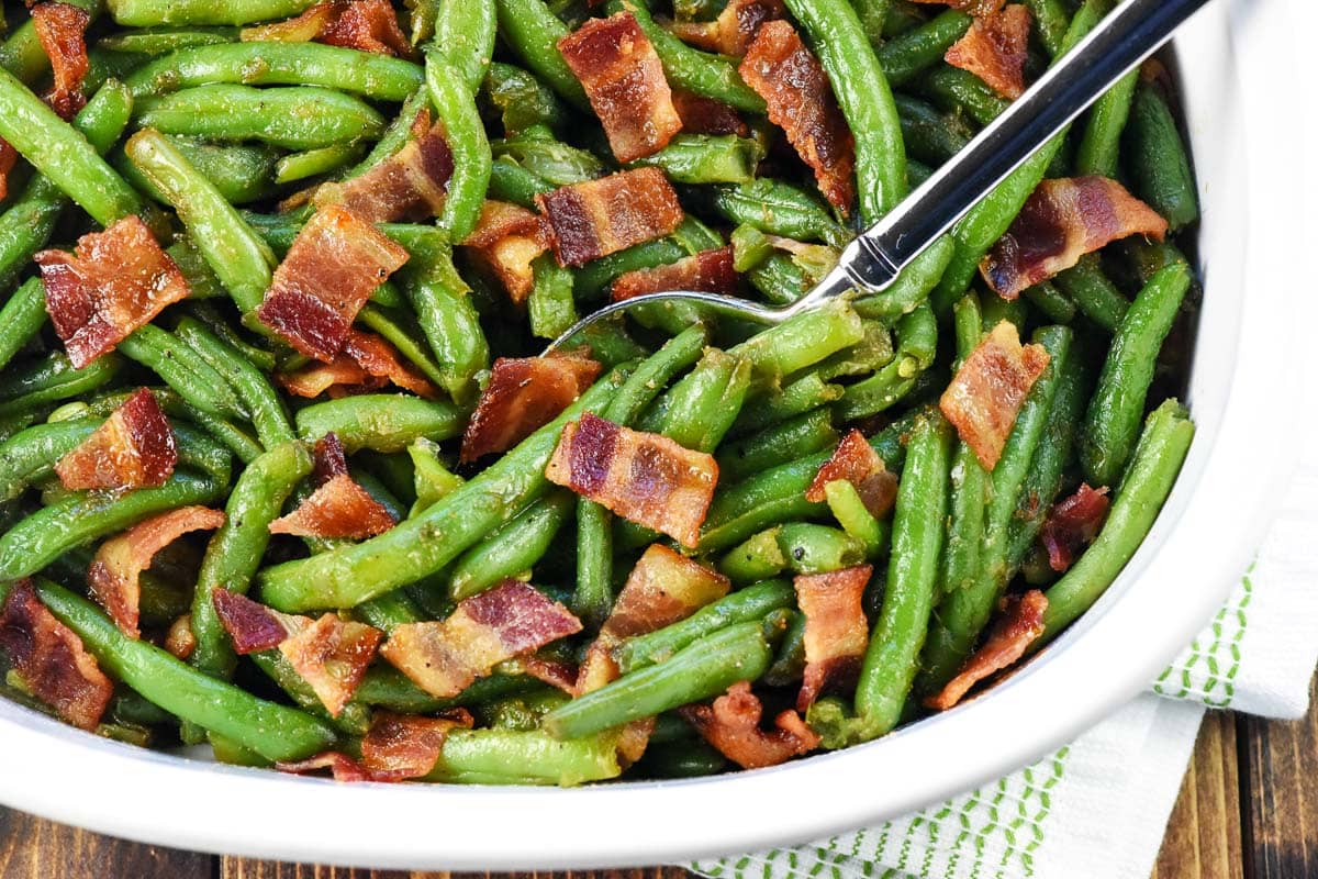 Green Bean Casserole with Bacon, in dish with serving spoon.