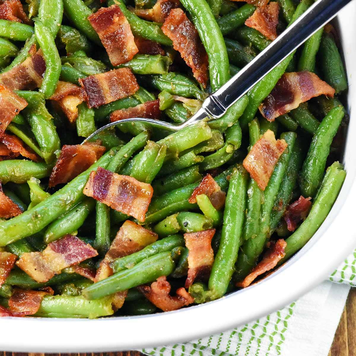 Green Bean Casserole with Bacon close-up in dish with serving spoon.