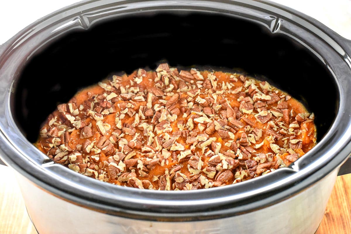 Slow Cooker Sweet Potato Casserole with pecans in crockpot.