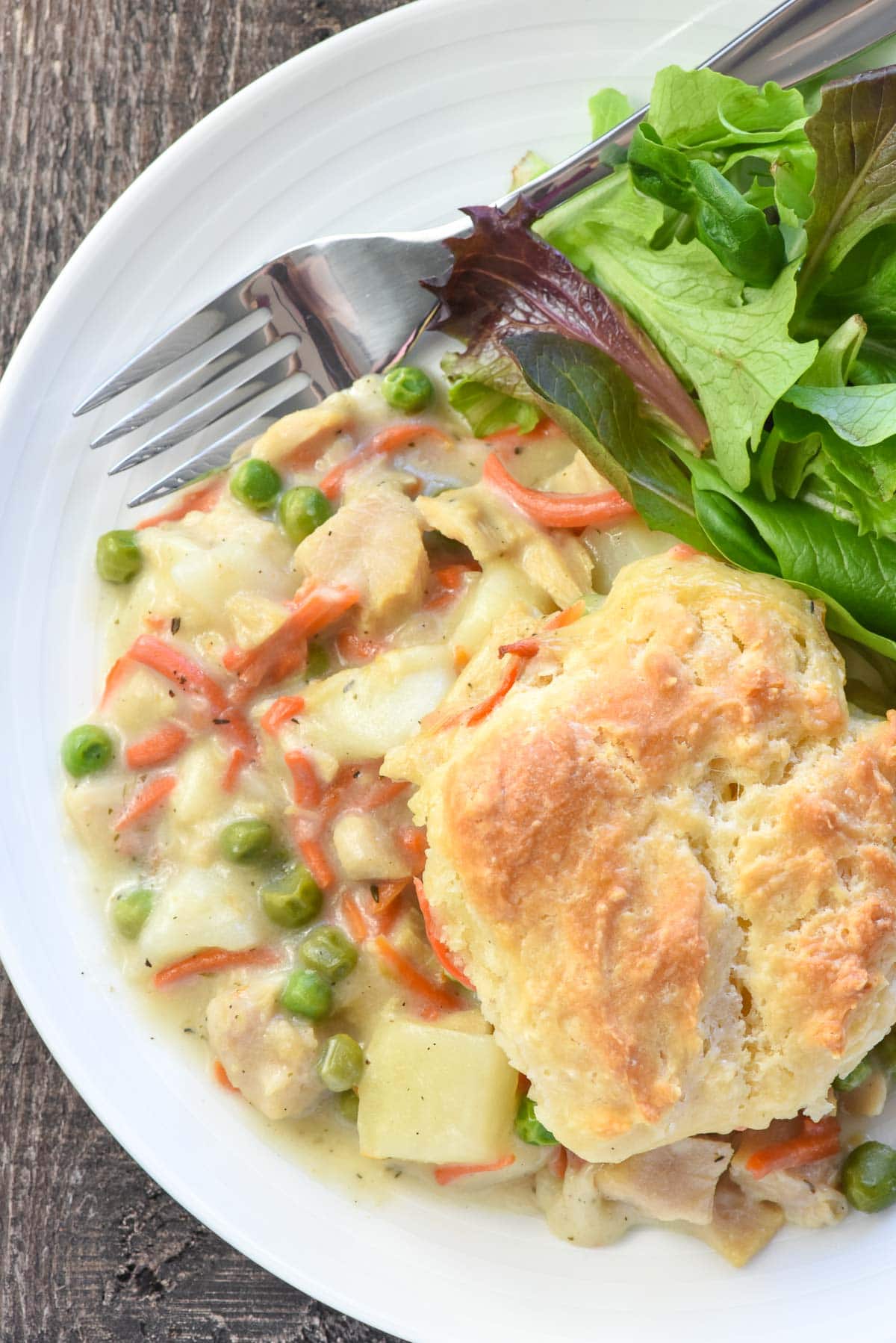 Aerial view of Chicken Pot Pie Casserole with salad on plate.