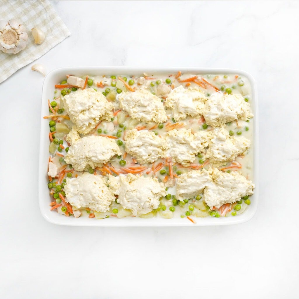 Chicken Pot Pie Casserole with biscuits ready for oven.