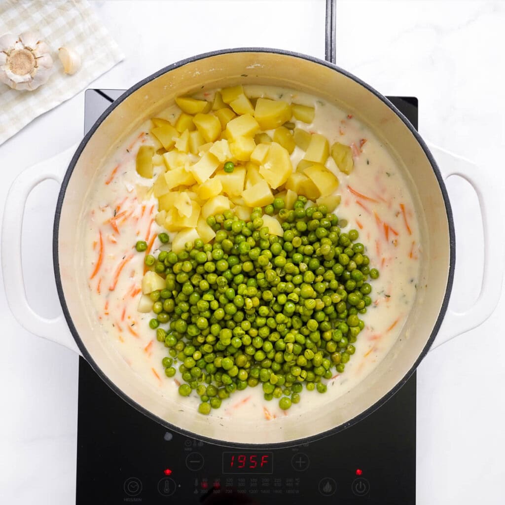 Adding potatoes and peas.