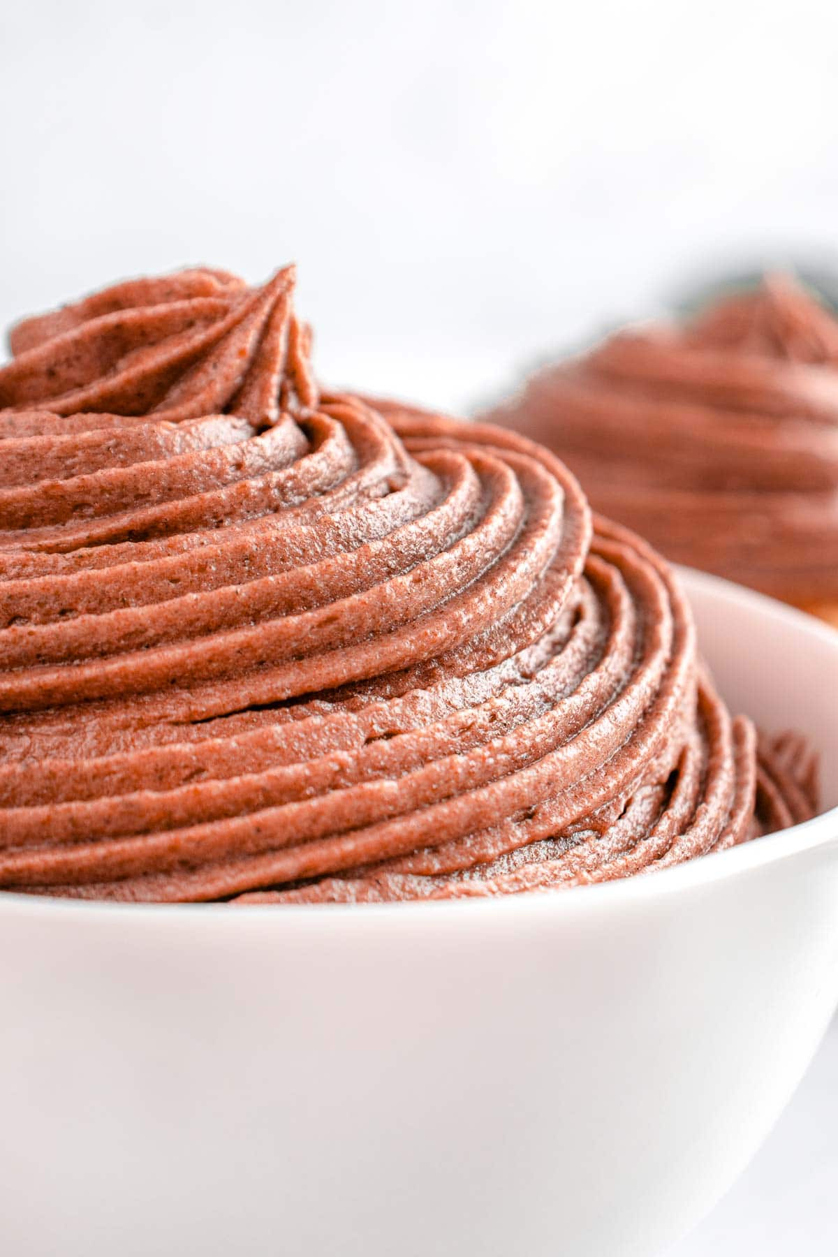 Chocolate Cream Cheese Frosting piped into white bowl.