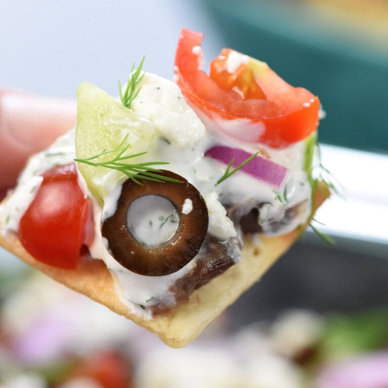 Greek 7-Layer Dip on cracker.