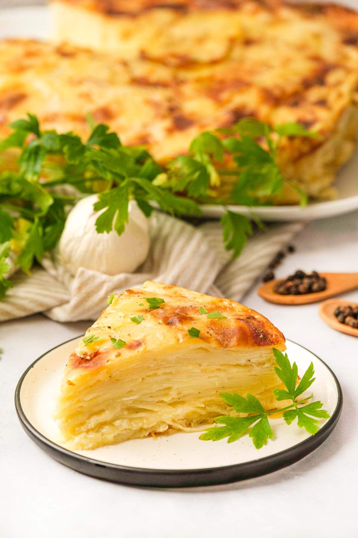 Gruyere Scalloped Potatoes on plate and serving dish.