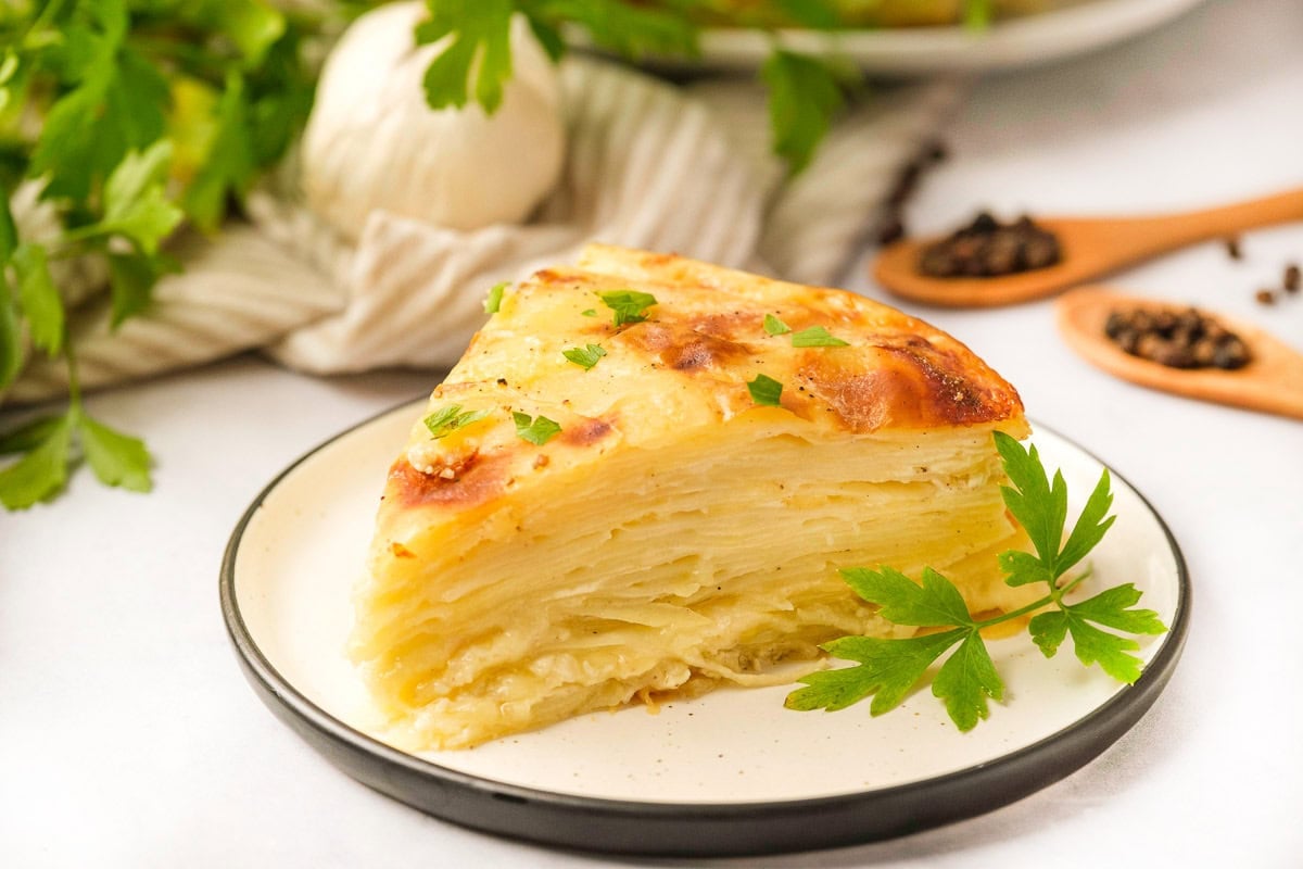 Gruyere Scalloped Potatoes on plate with fresh parsley.