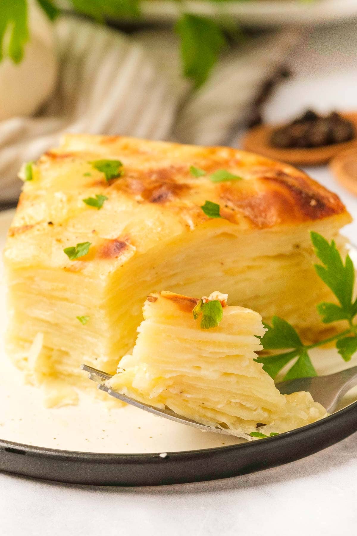 Gruyere Scalloped Potatoes recipe with bite on fork.