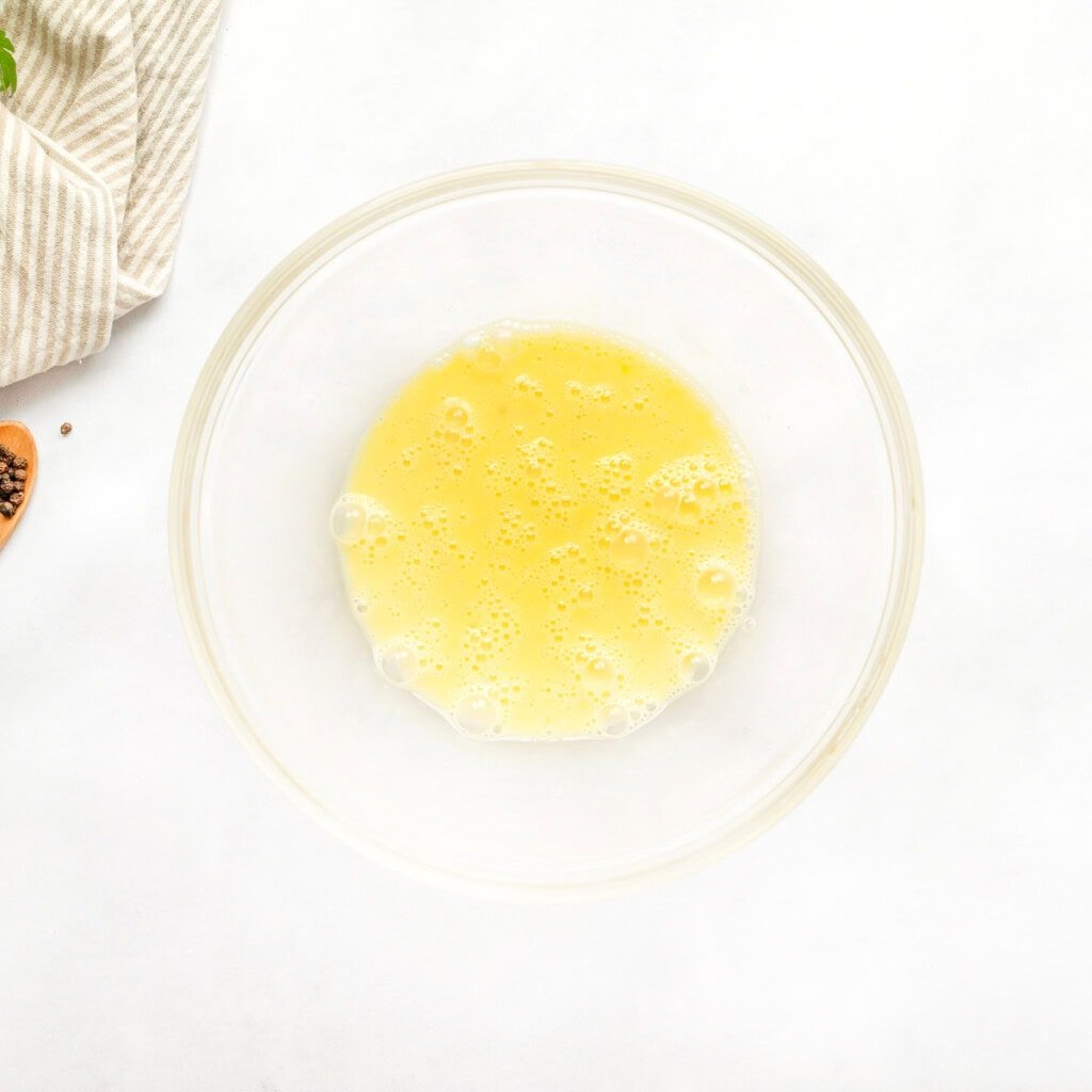 Eggs whisked in bowl.