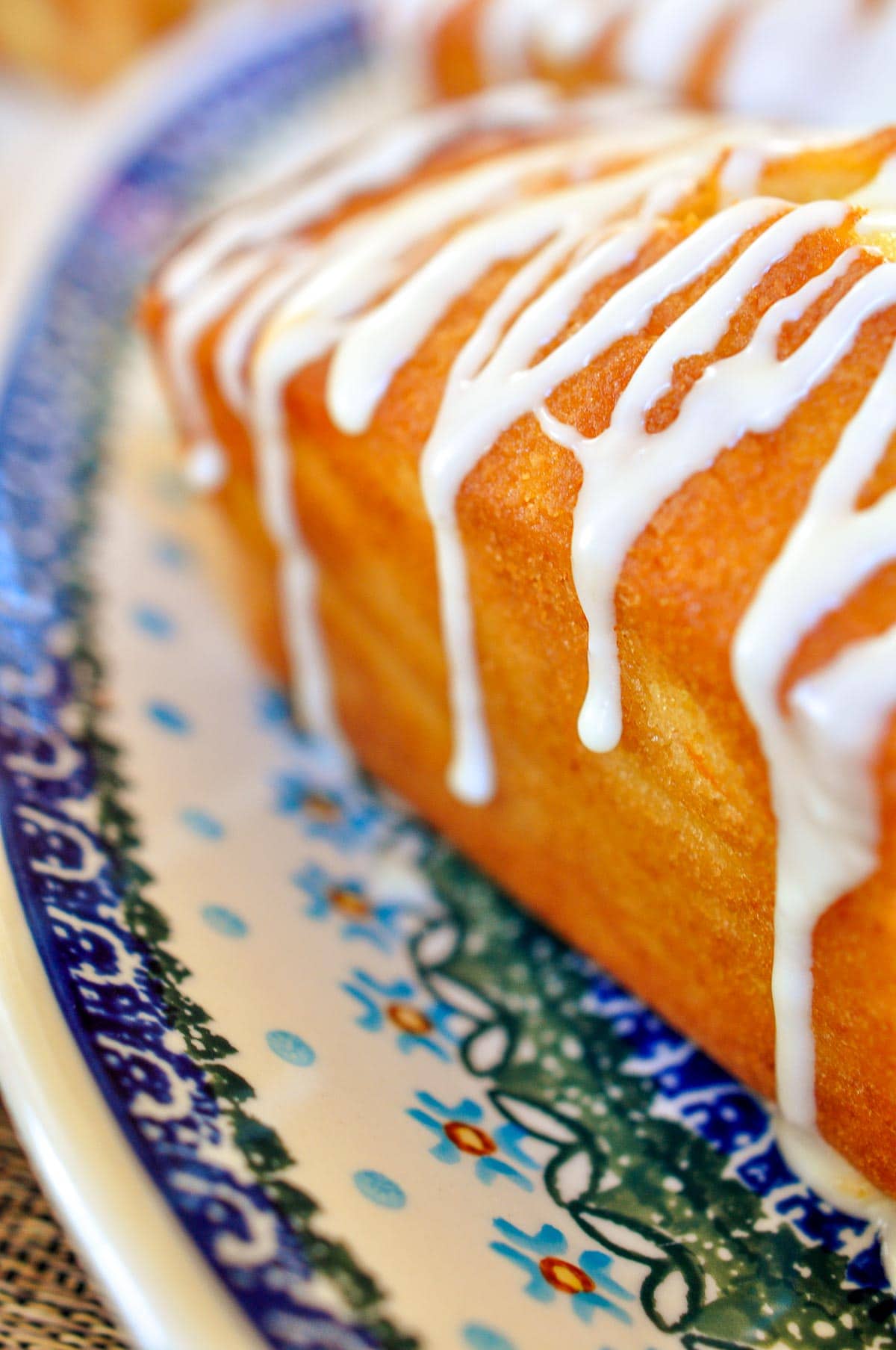 Orange glaze dripping down the side of Orange Pound Cake.