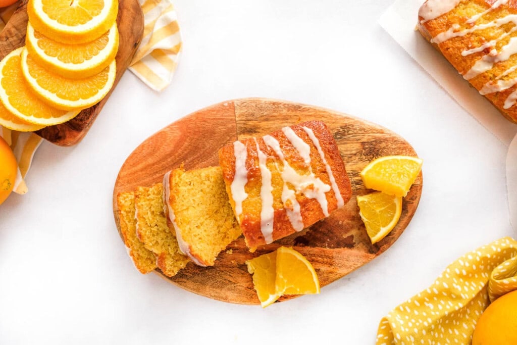 Orange Pound Cake sliced on wooded board.