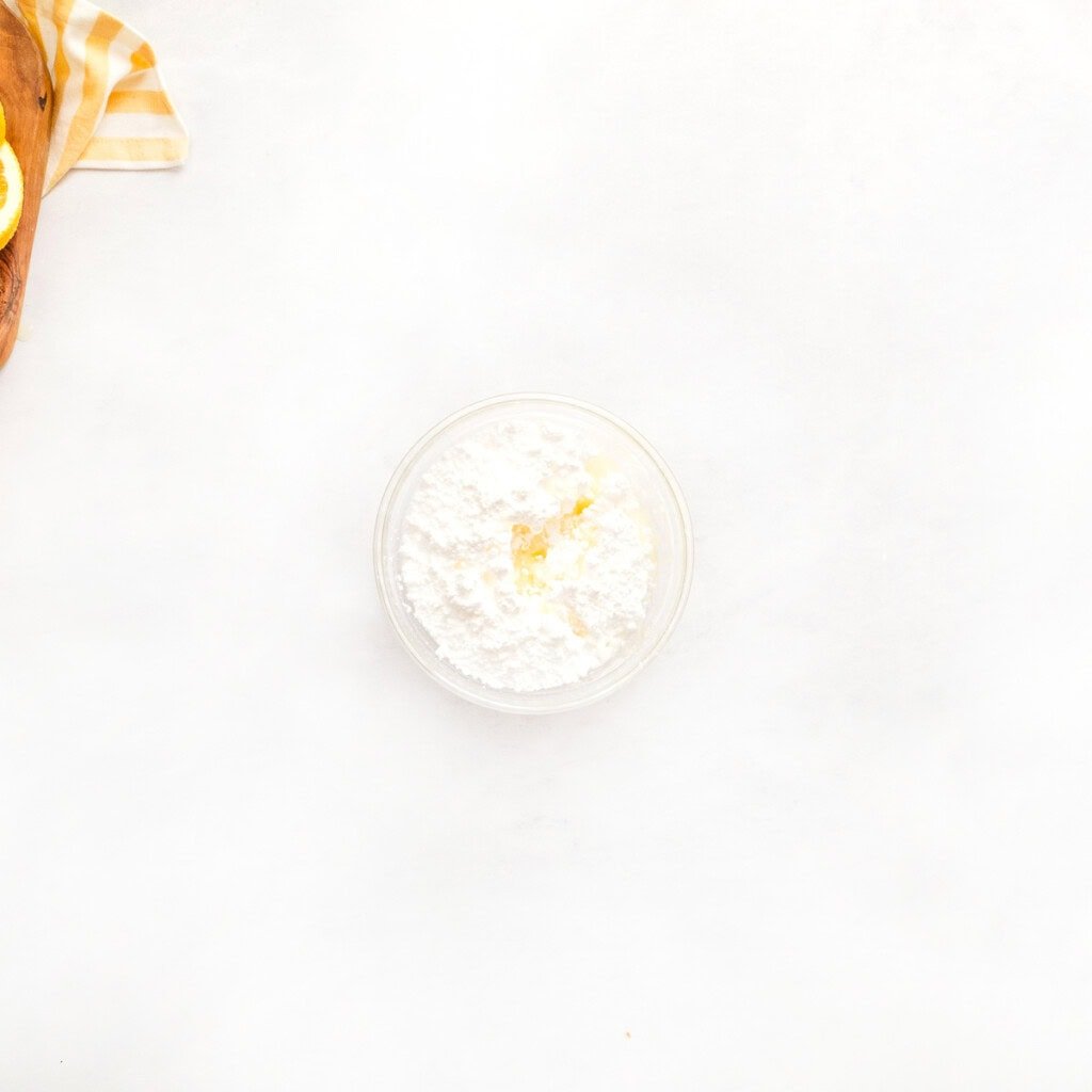 Powdered sugar and orange juice in bowl for glaze.